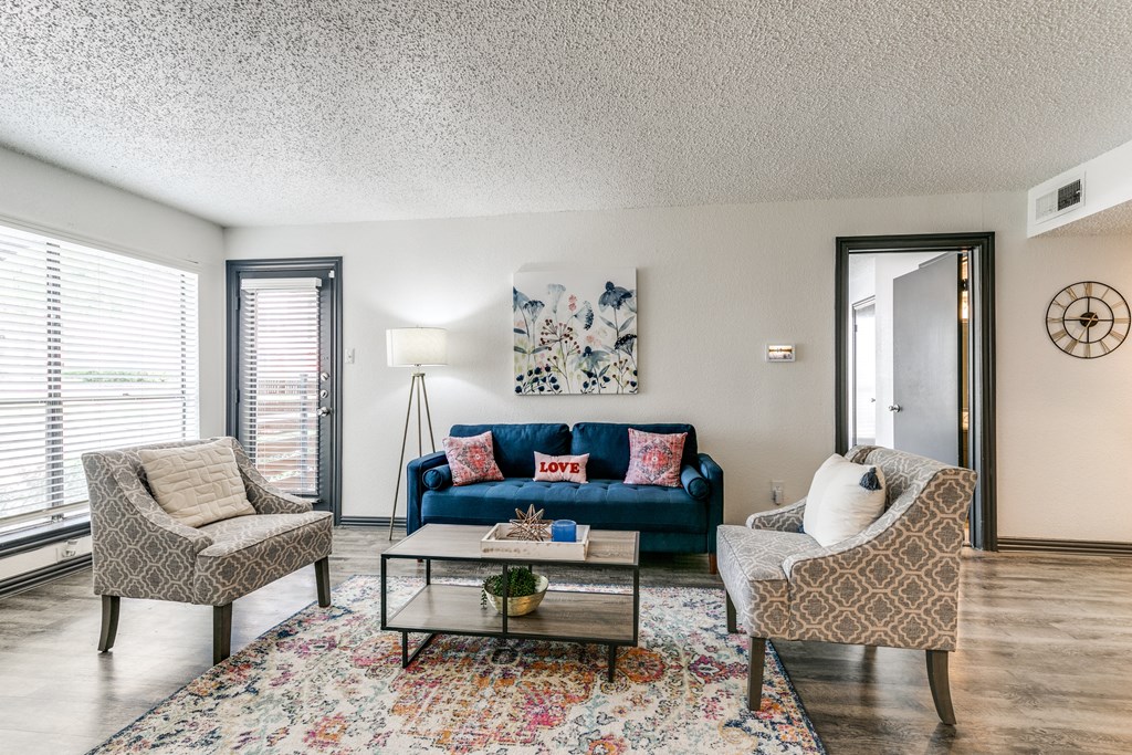 a living room with a blue couch and two chairs