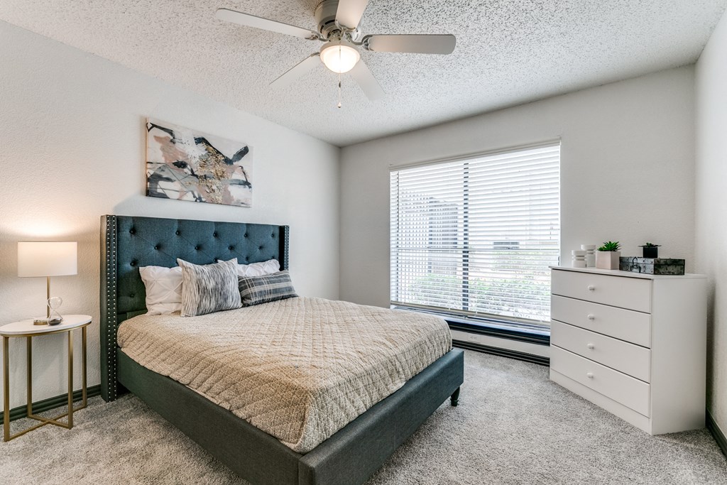 a bedroom with a bed and a ceiling fan
