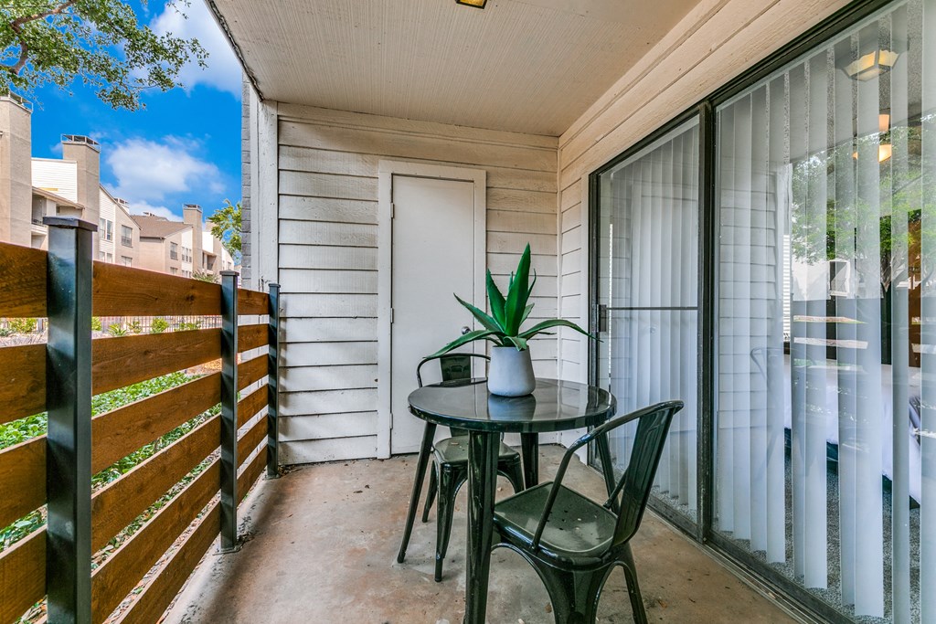 a patio with a table and chairs on a balcony