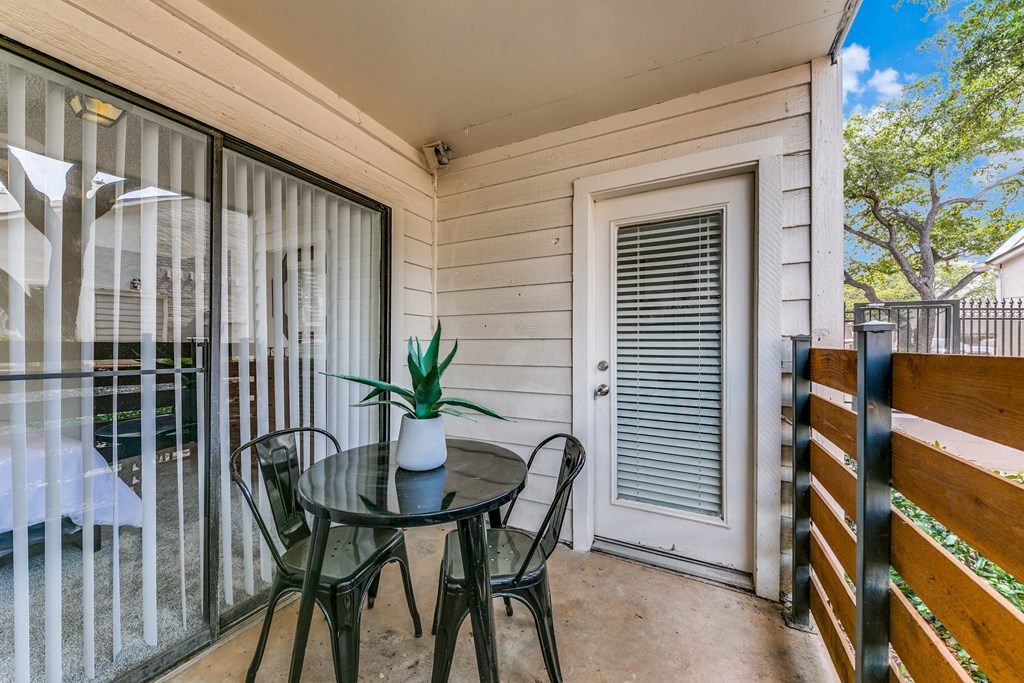 a patio with a table and chairs and a sliding glass door