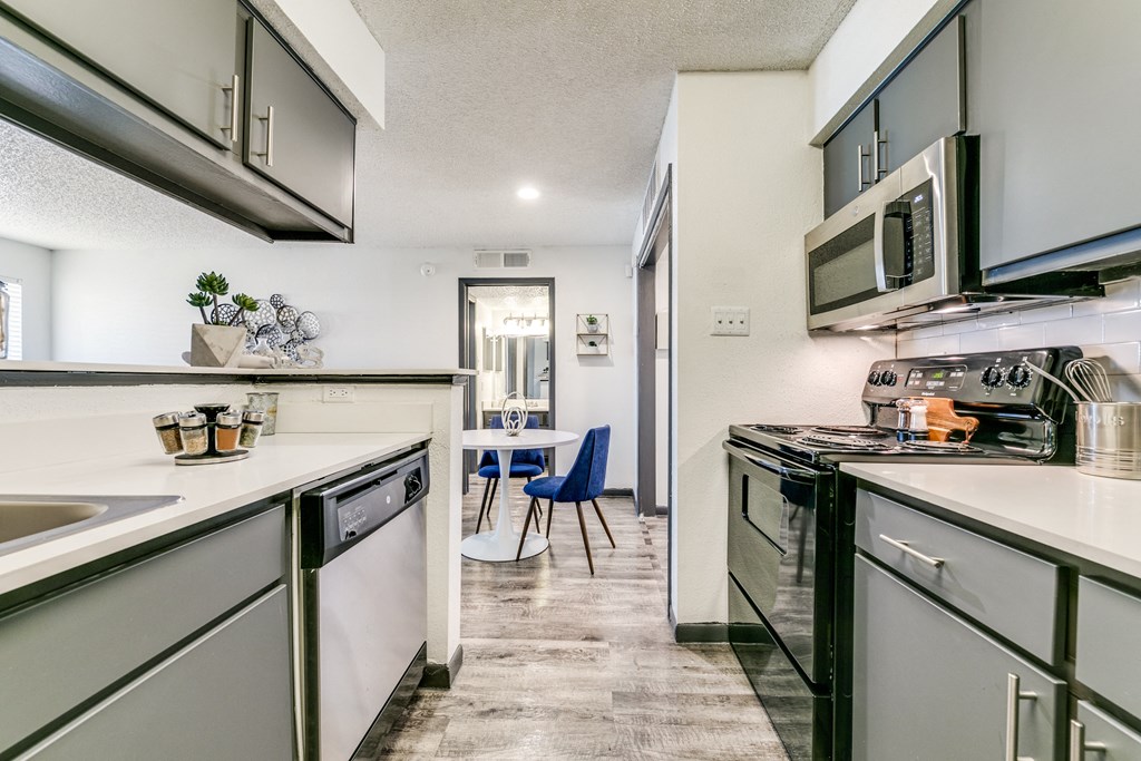 a kitchen with white cabinets and appliances and a dining room with a table