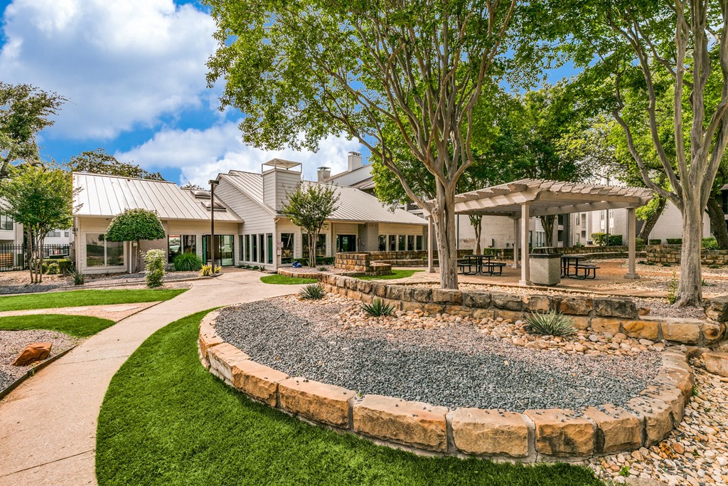 a courtyard with trees and a building in the background