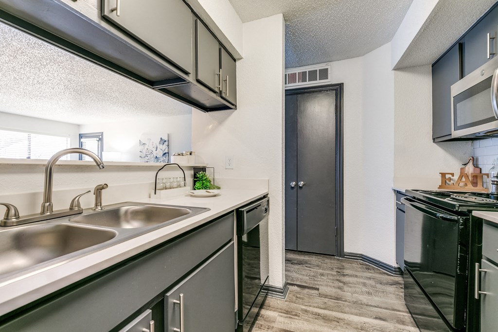 the kitchen of our apartments has a stainless steel counter top and a sink