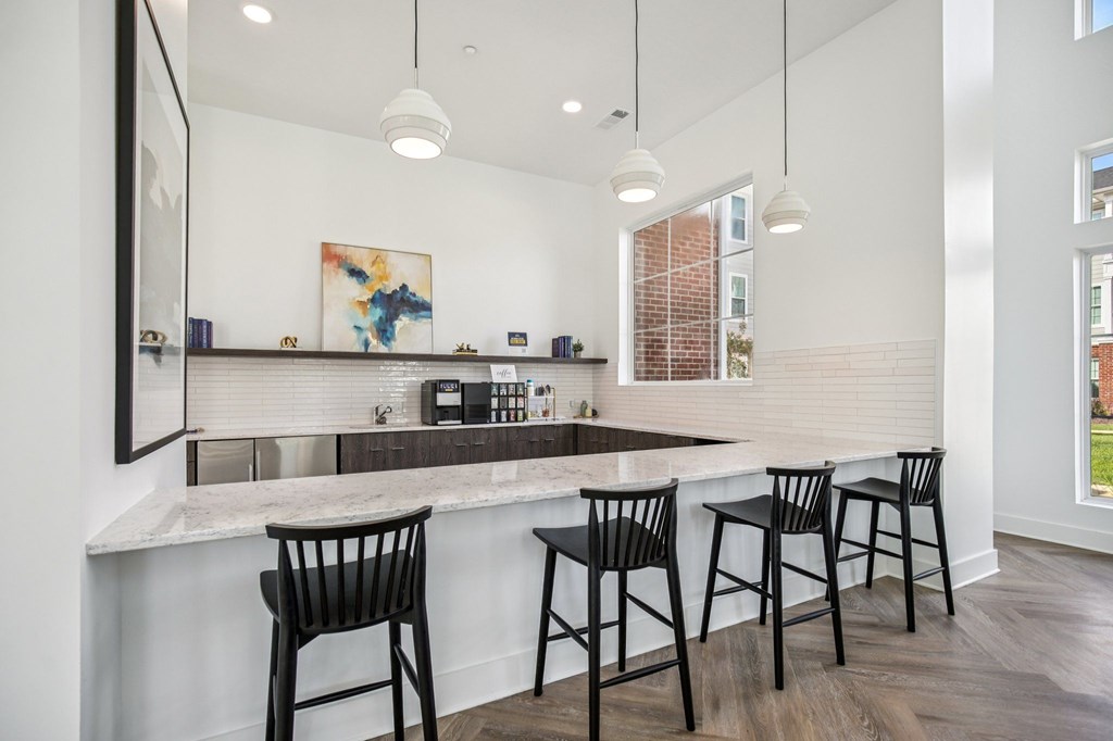 A kitchen with a bar area and three bar stools.