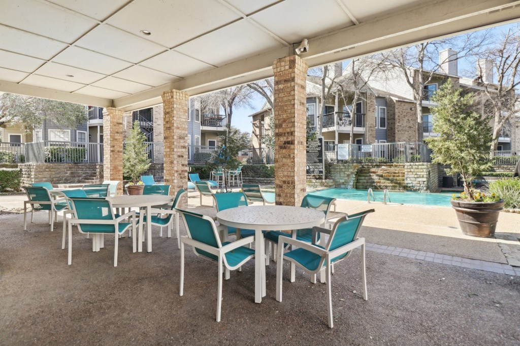 A patio with a table and chairs under a white canopy.