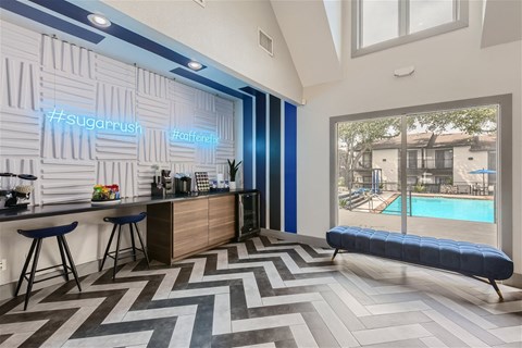 a lobby with a pool and a bar with stools