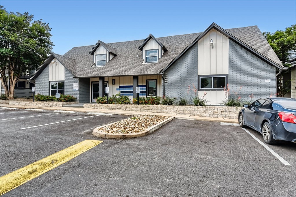 a house with a parking lot and a car in front of it