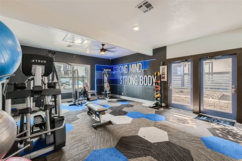 a home gym with weights and cardio equipment and a sliding glass door