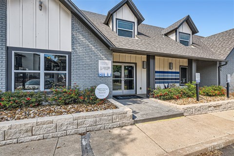 the front of a gray house with a sidewalk in front of it