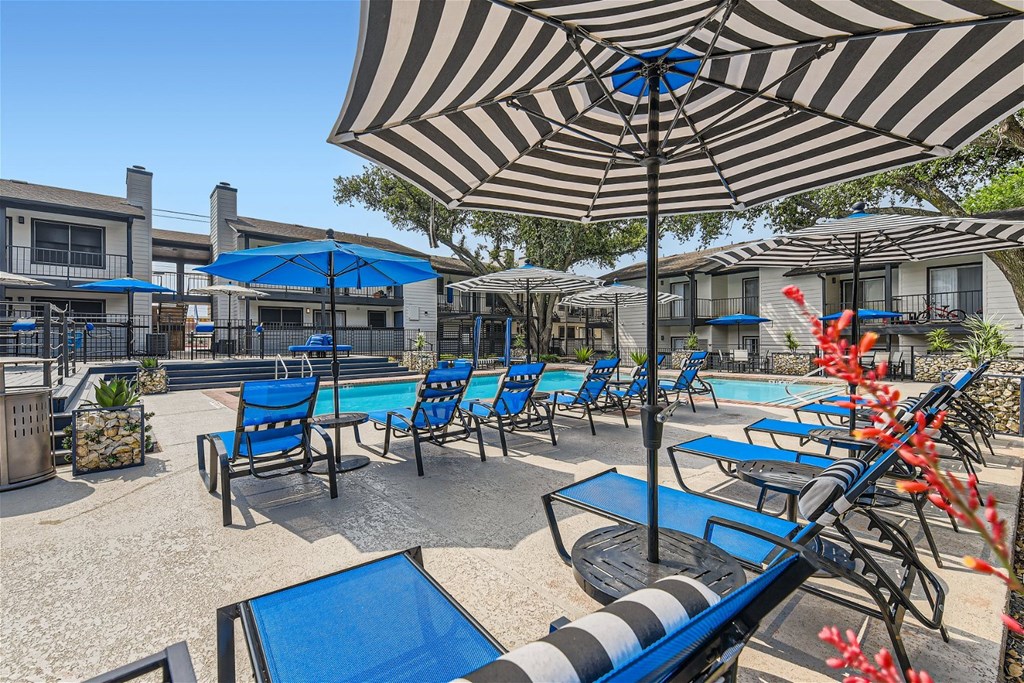 our patio is full of chairs and umbrellas and a pool