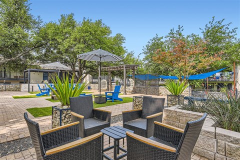a patio with chairs and umbrellas and a hammock