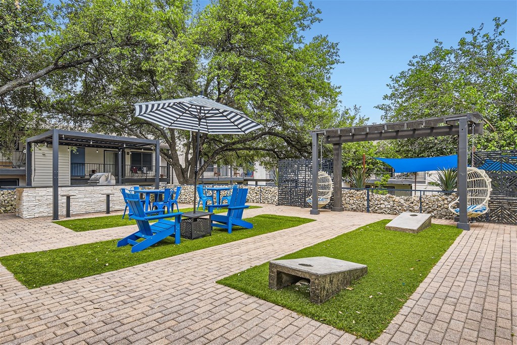 a patio with blue chairs and umbrellas and a picnic table