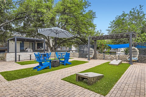 a patio with blue chairs and umbrellas and a picnic table