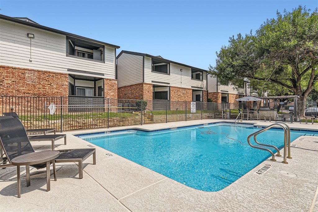 a swimming pool with chairs and a building with colorful walls