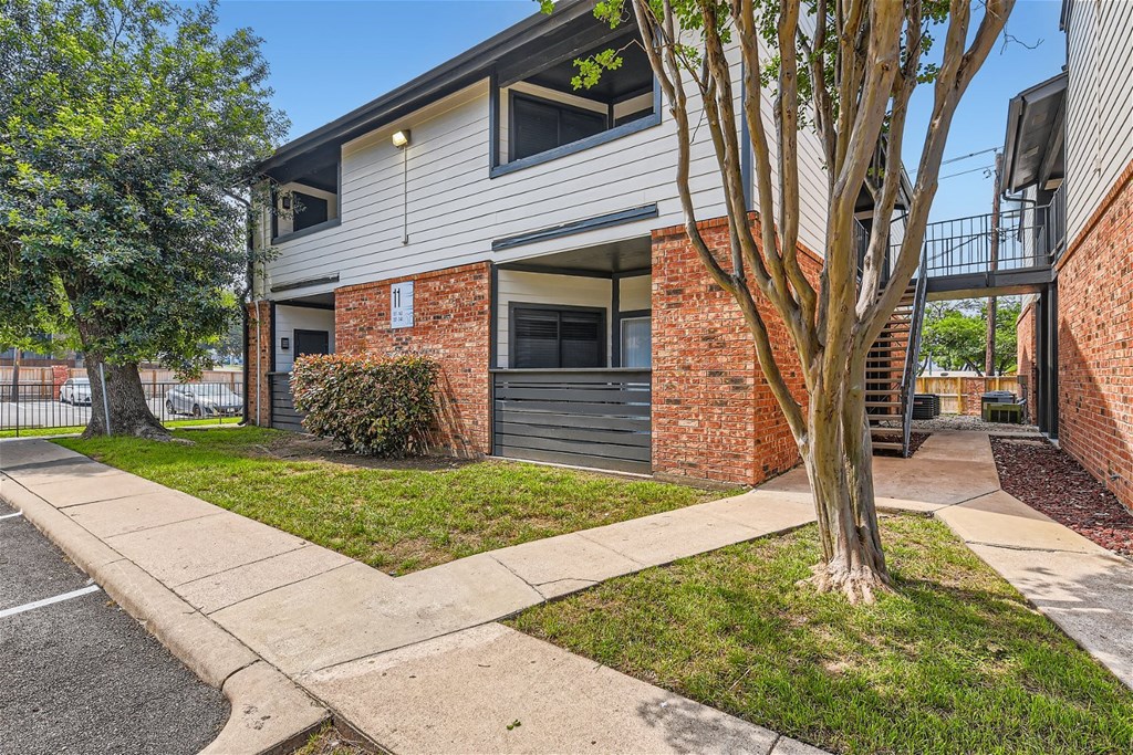 the front of a house with a sidewalk and trees