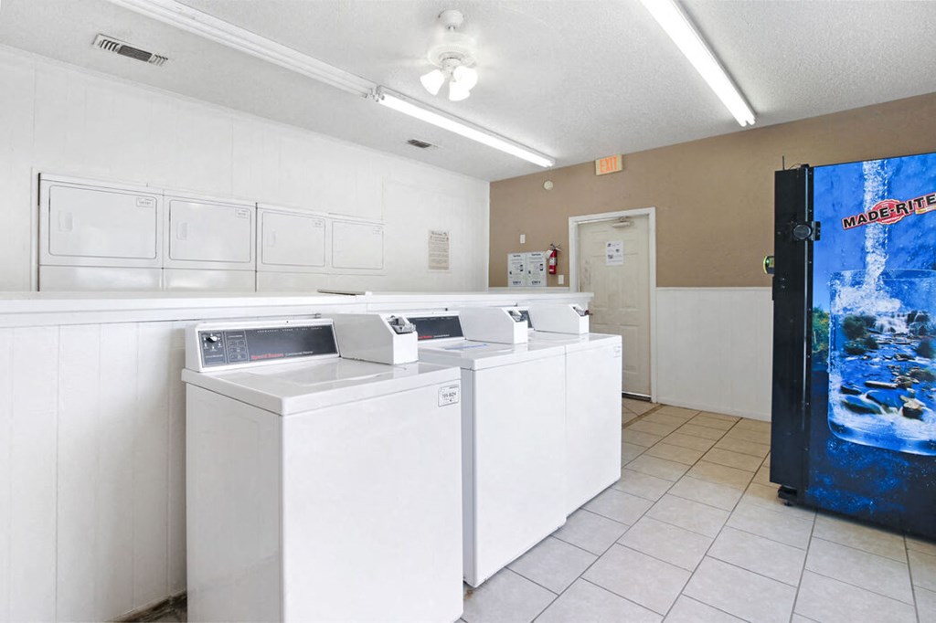 an empty restroom with white counters and white sinks