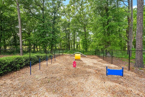 A playground with a yellow slide and a blue barrier.
