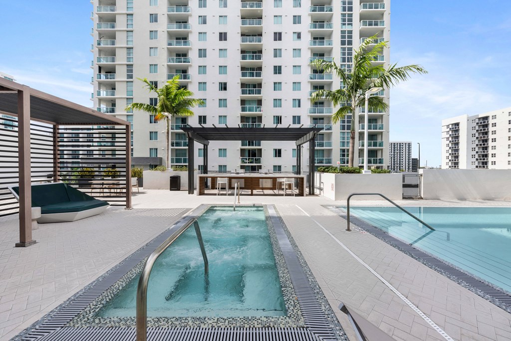 a pool and hot tub on a roof with a building in the background