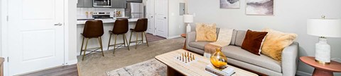 A living room with a grey couch and a wooden coffee table.