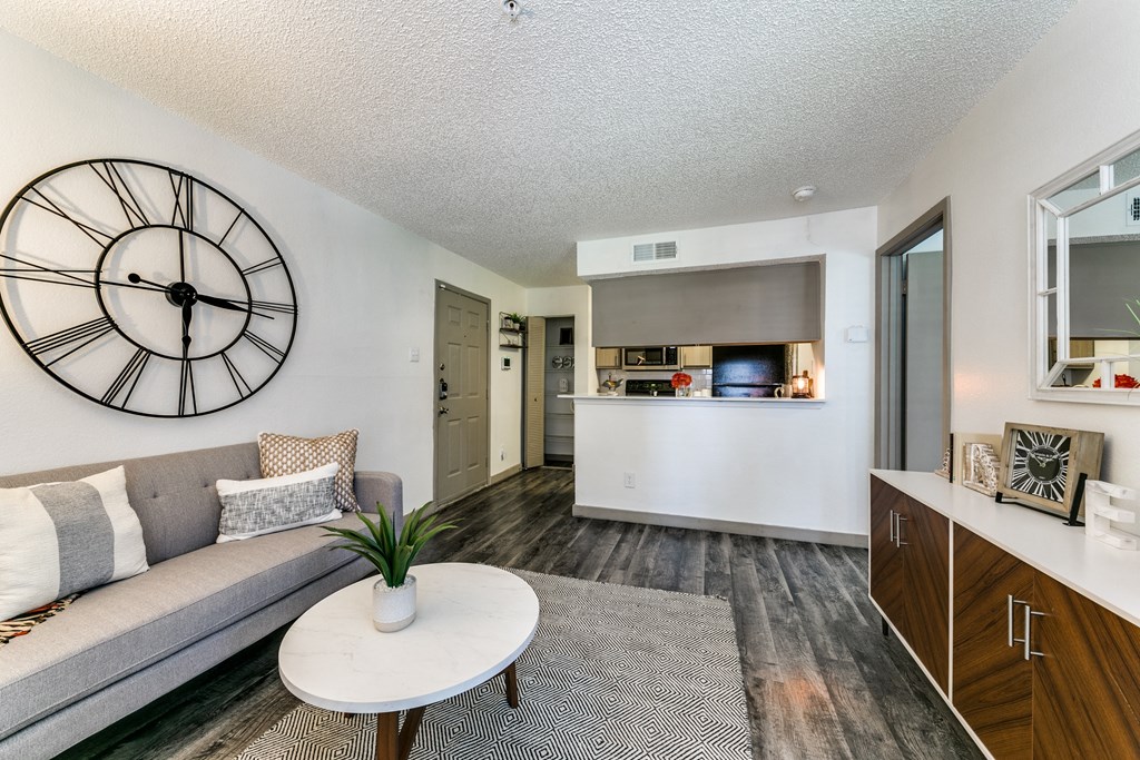 an open living room and kitchen with a large clock on the wall