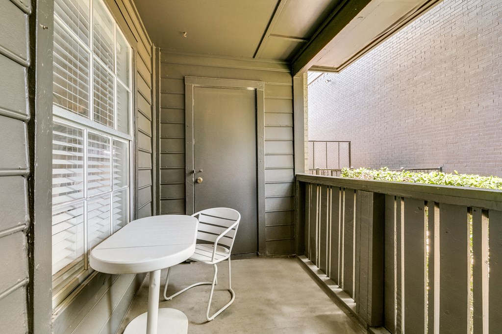 a balcony with a table and chairs and a door