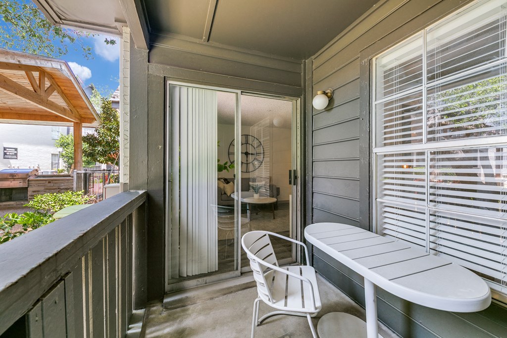 a balcony with a table and chairs and a door to a patio