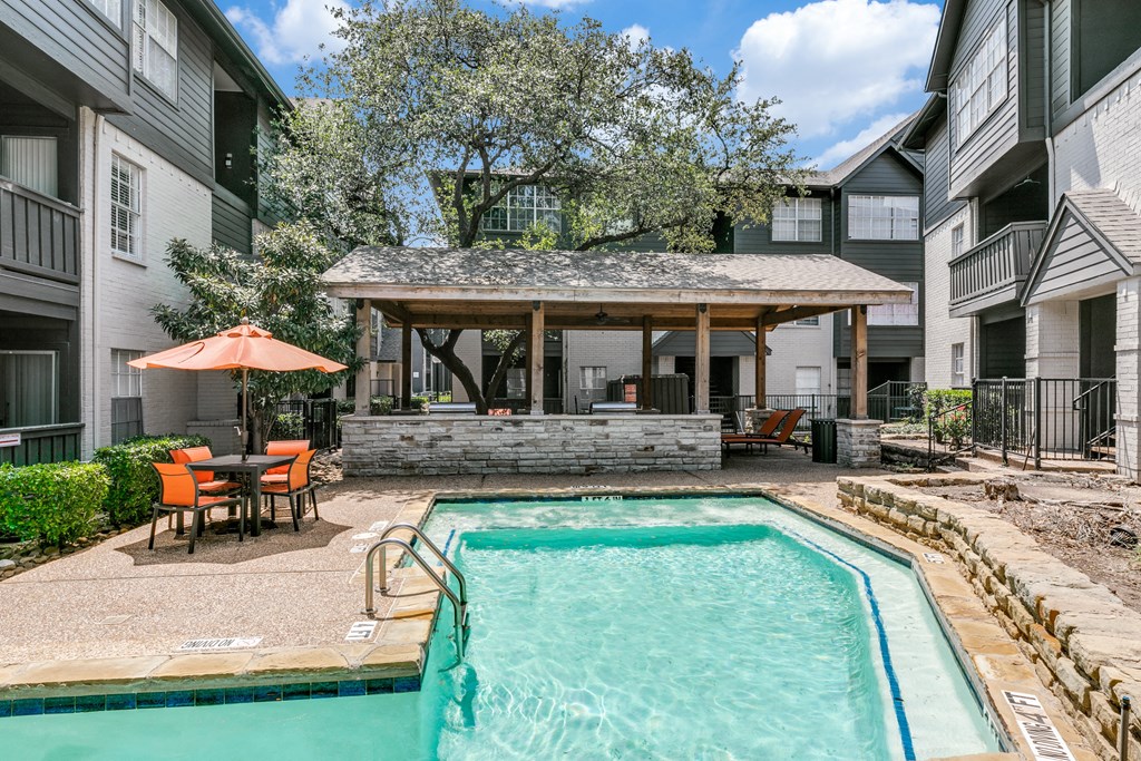 our apartments have a swimming pool and a patio with a table and chairs