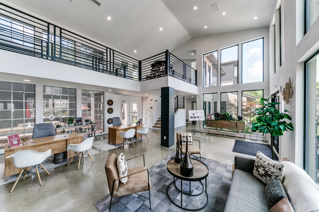 a living room with couches and chairs and a large balcony