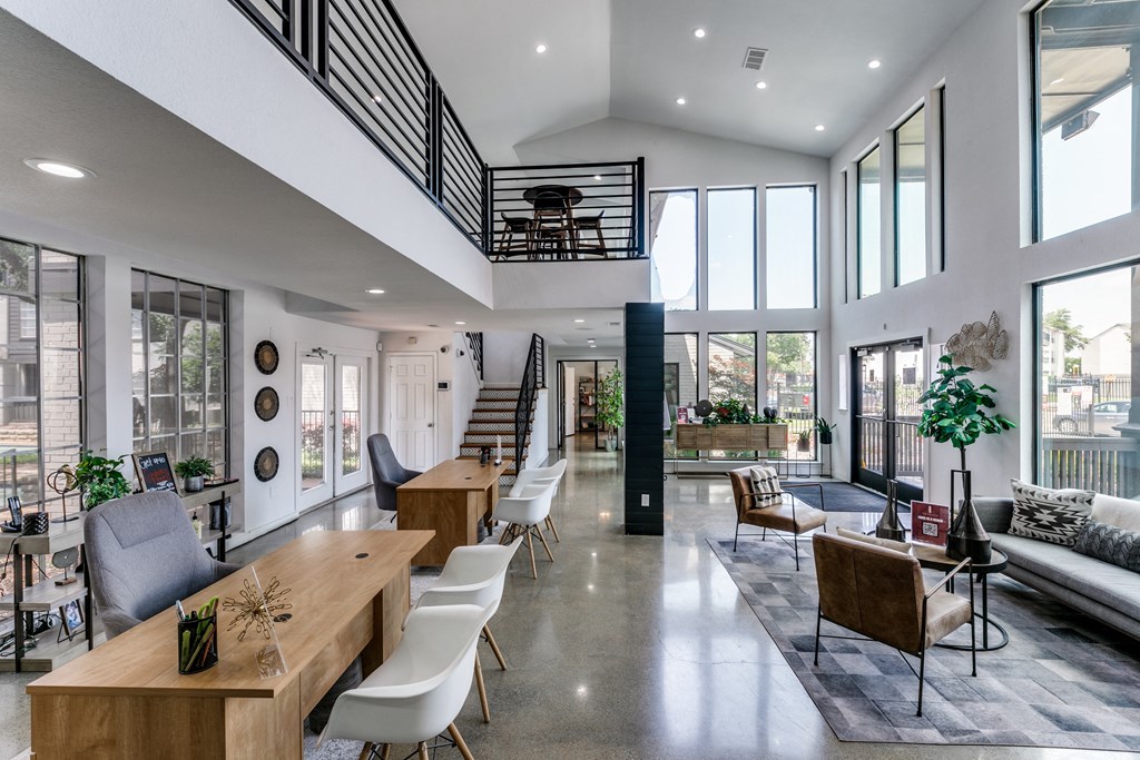 the living room and dining area of a house with large glass windows and a staircase