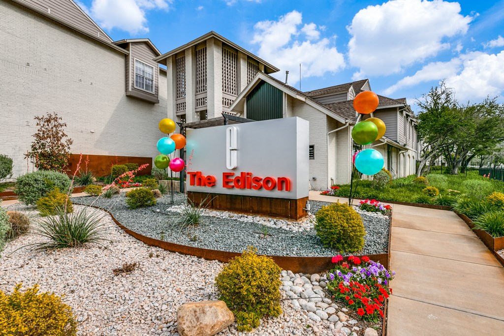 the eison apartments sign in front of a home with colorful balloons