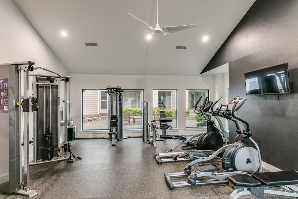 a home gym with exercise machines and a tv