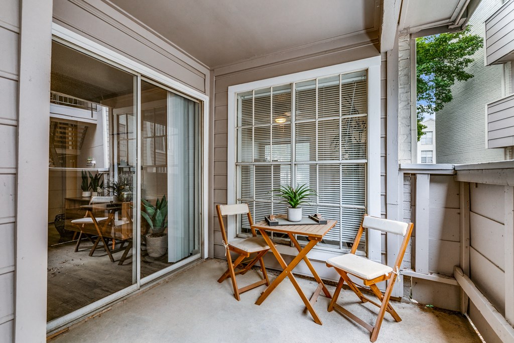 a patio with a table and chairs and a sliding glass door