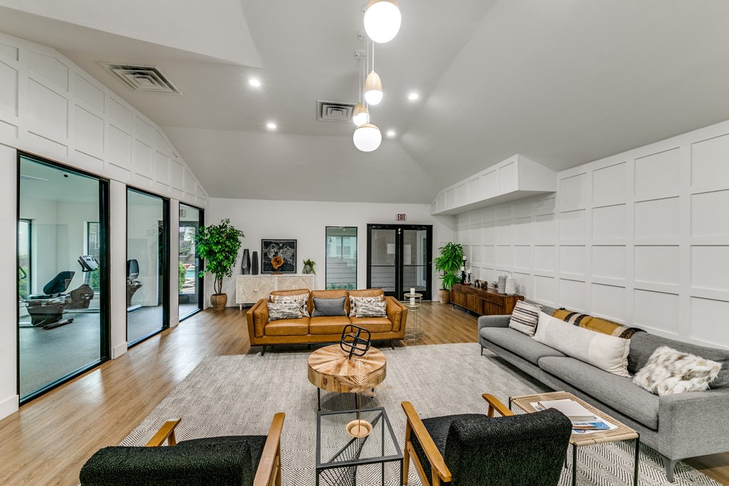 a living room with couches and chairs and a rug