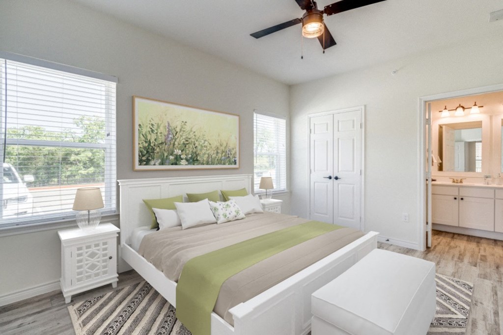 a bedroom with a large bed and a ceiling fan