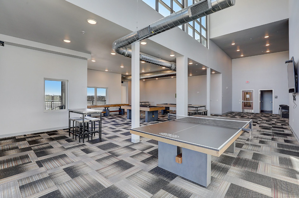 a game room with a ping pong table and tables