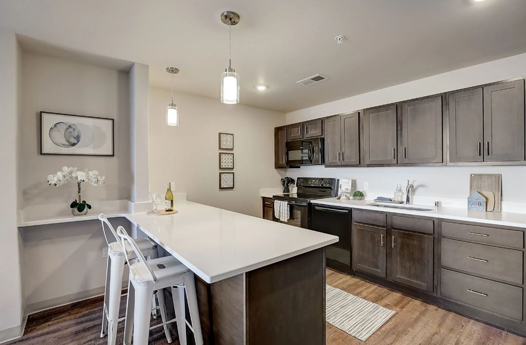 a kitchen with a white counter top and wooden cabinets