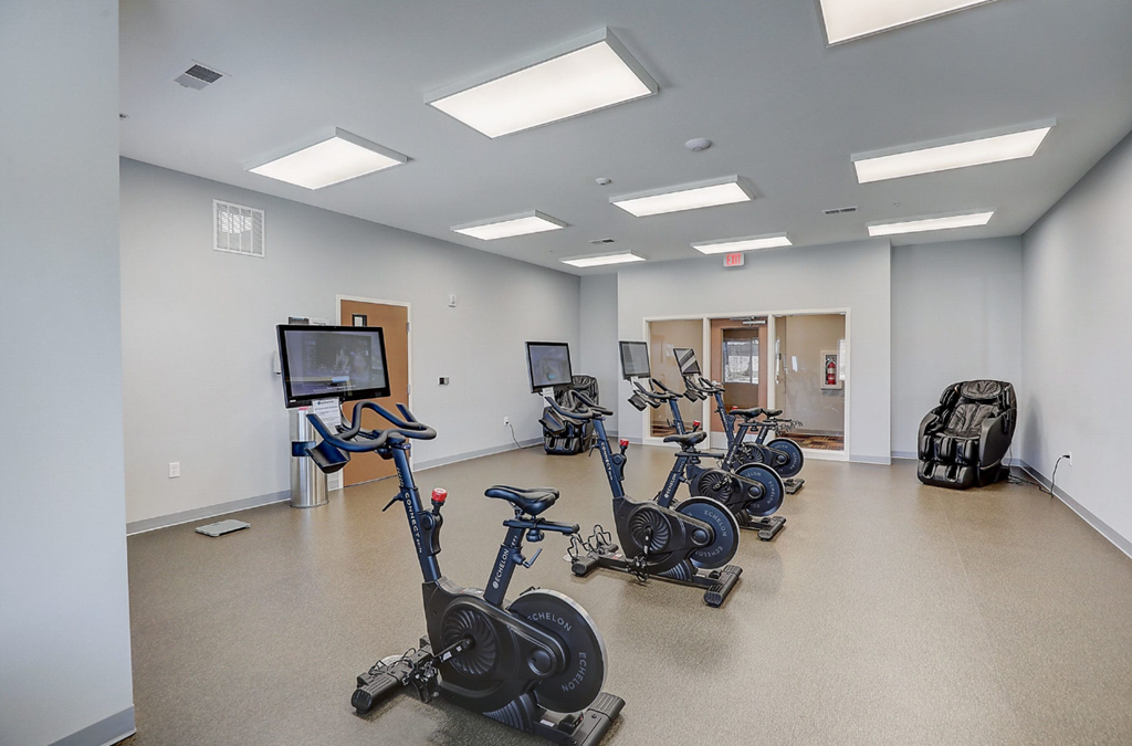 a fitness room with exercise bikes and cardio equipment