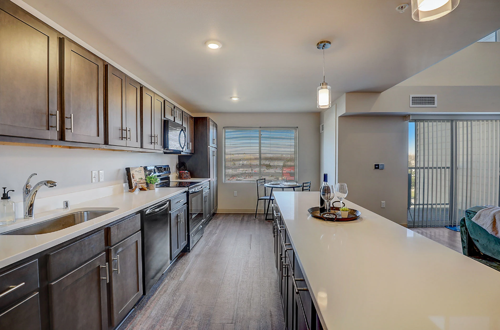 a kitchen with stainless steel appliances and a long counter top