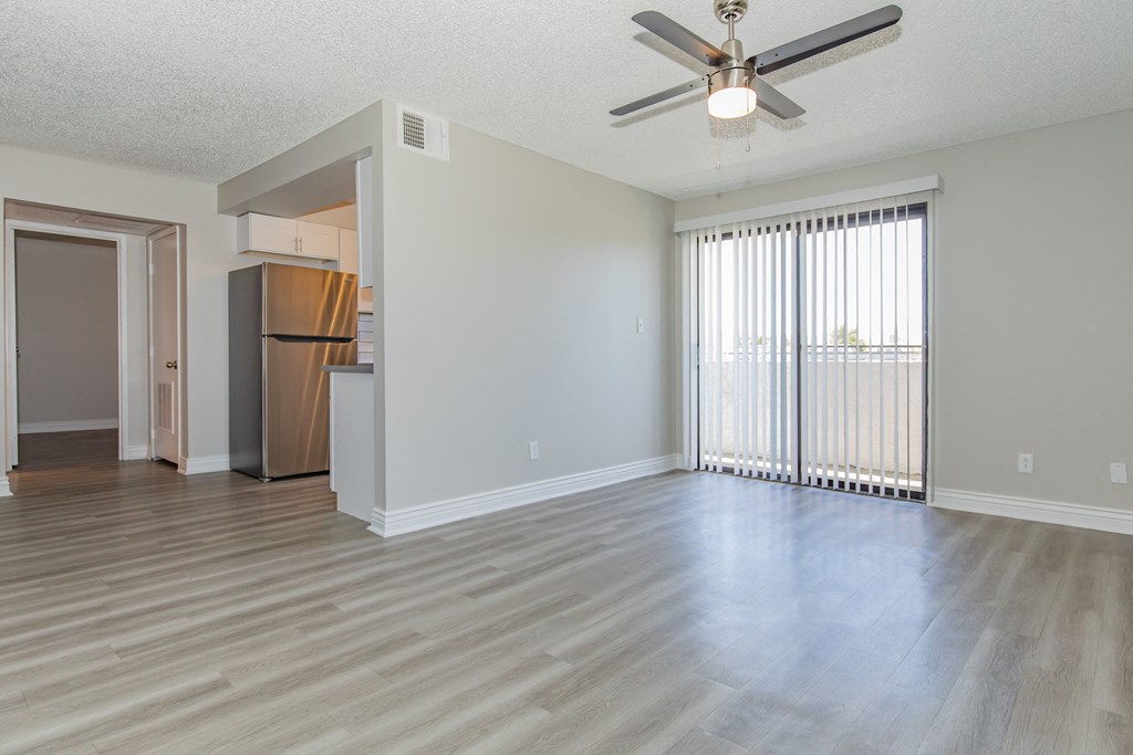 an empty living room with a ceiling fan