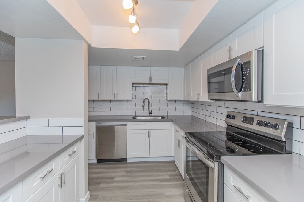 a kitchen with white cabinets and stainless steel appliances