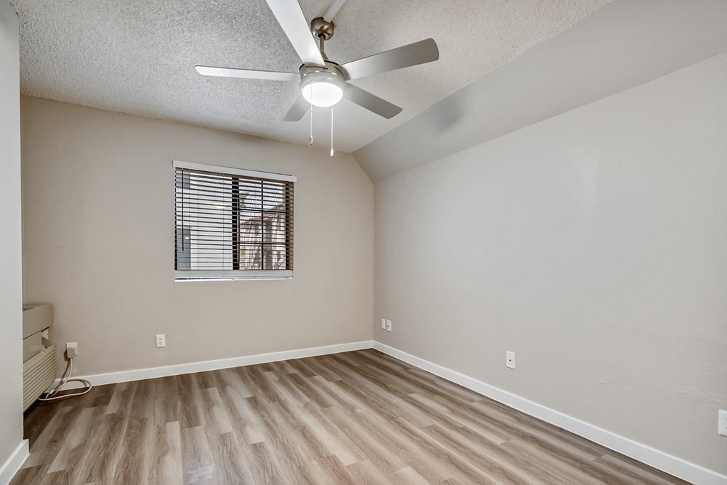 an empty bedroom with a ceiling fan