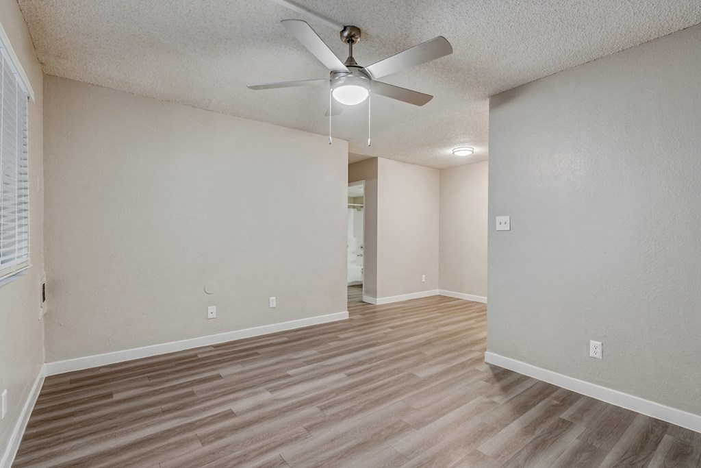 a bedroom with hardwood floors and a ceiling fan