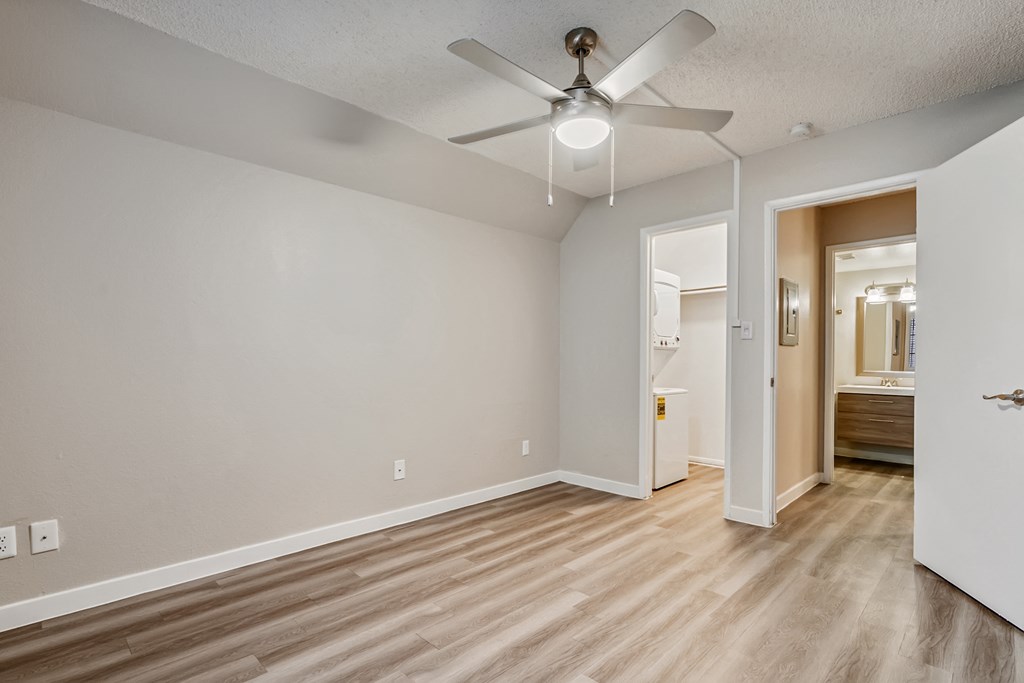 a bedroom with hardwood floors and a ceiling fan