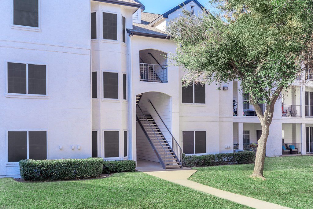 a large white building with a tree in front of it