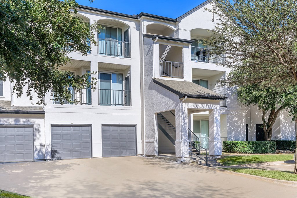 a large white apartment building with two garages