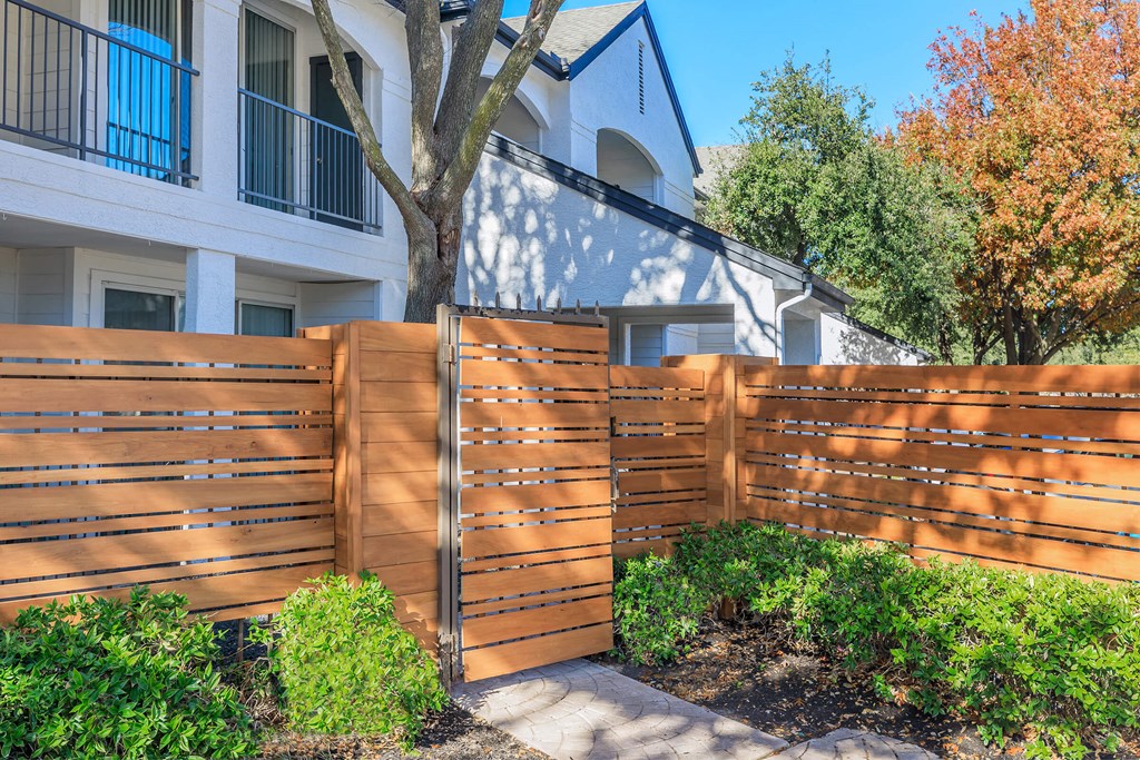 a wooden fence in front of a white building