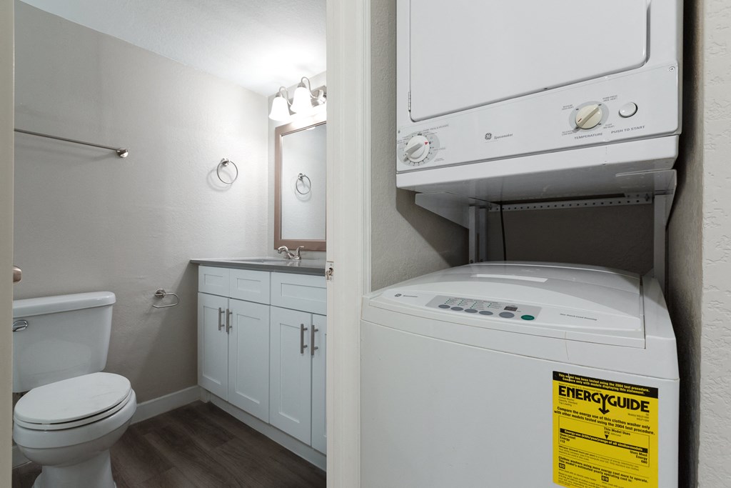 a bathroom with a washer and dryer and a toilet