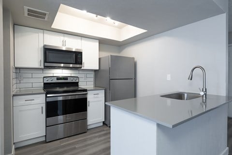 an empty kitchen with stainless steel appliances and a counter top