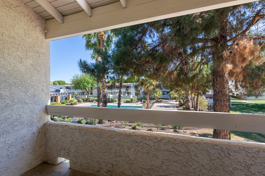 a balcony with a view of a tree and a pool