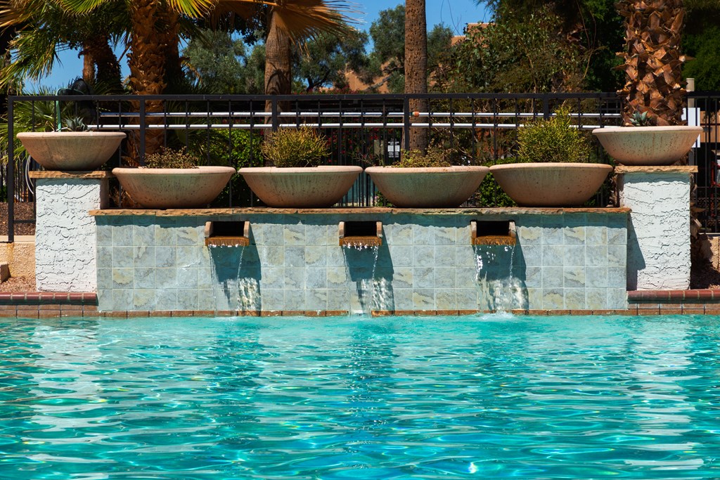 a swimming pool with a row of flower pots on the side